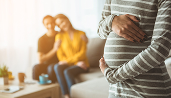 A pregnant woman gently holds her stomach