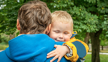 A touching moment captured in a park as a father and his son hug